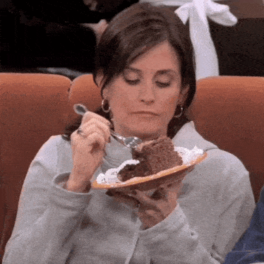 a woman is eating a slice of chocolate cake with a fork