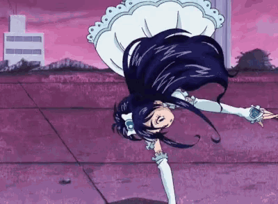 a girl in a white dress is doing a handstand in front of a building