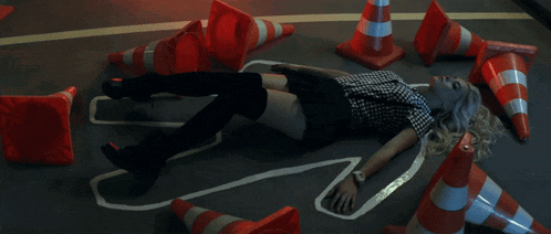 a woman laying on the ground with a silhouette drawn on the floor