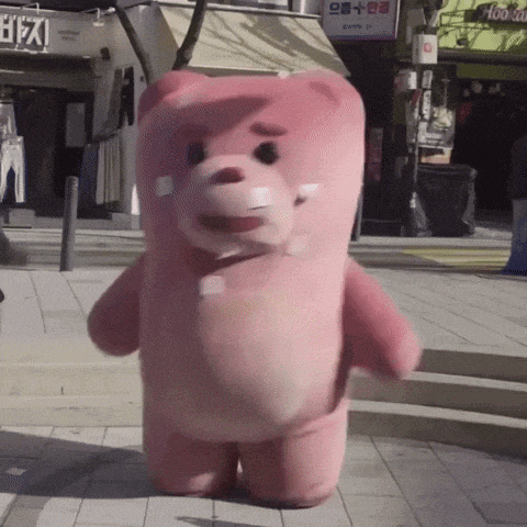 a pink teddy bear is walking down a sidewalk in front of a store that says hookah on it