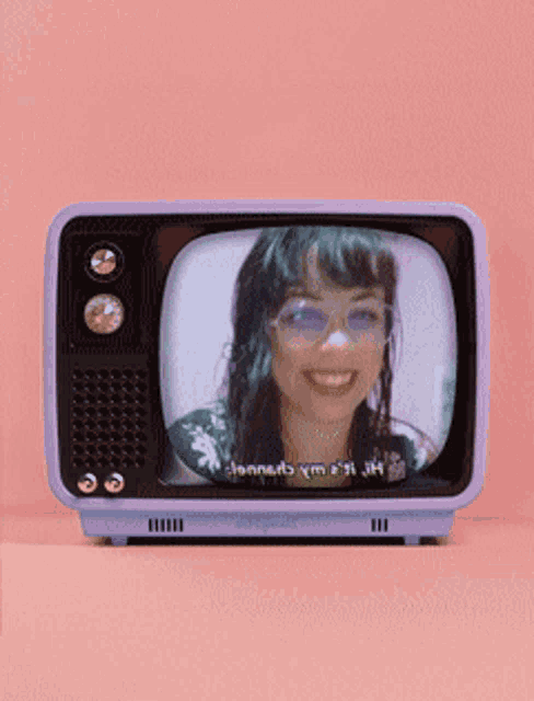 a purple television with a picture of a smiling woman on it