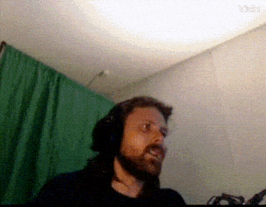 a man with a beard is wearing headphones in front of a green screen ..