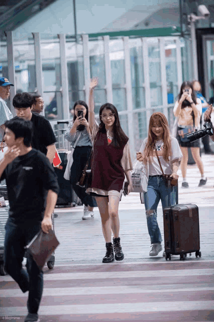 a woman wearing a t-shirt that says ' i love you ' on it walks down the street