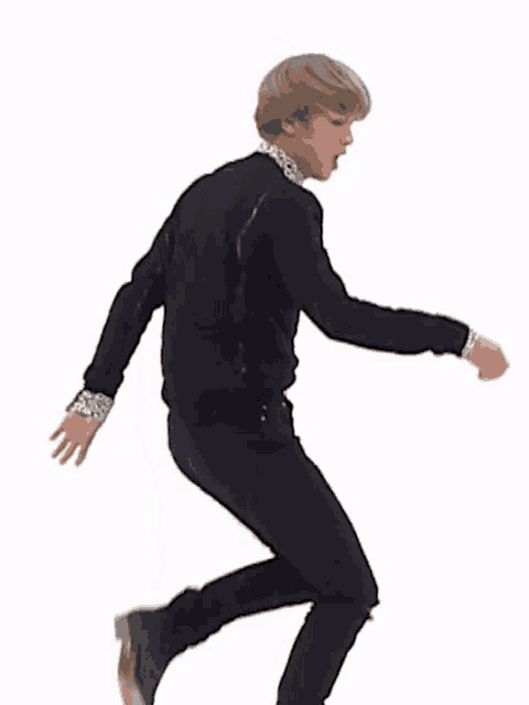 a man in a black jacket and black pants is dancing .