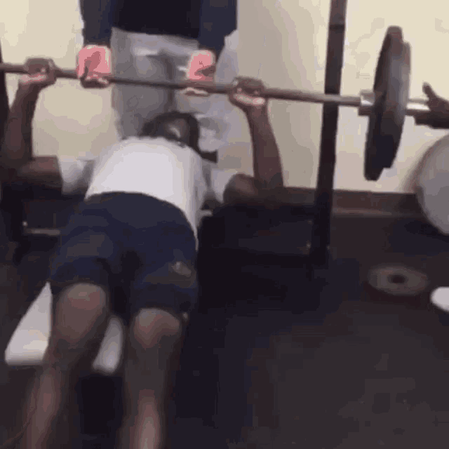 a man lifting a barbell on a bench