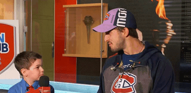 a man wearing a purple hat that says ' montreal ' on it