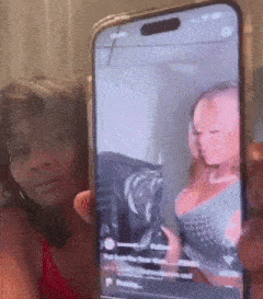 a woman is holding a cell phone with a picture of a woman .