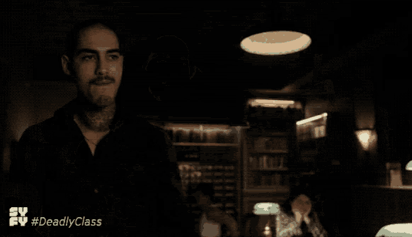 a man standing in a dark room with the hashtag #deadlyclass