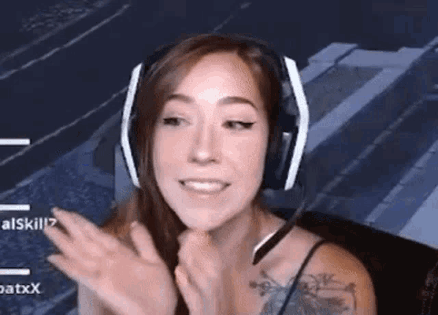 a woman wearing headphones and a microphone is sitting in front of a computer monitor .