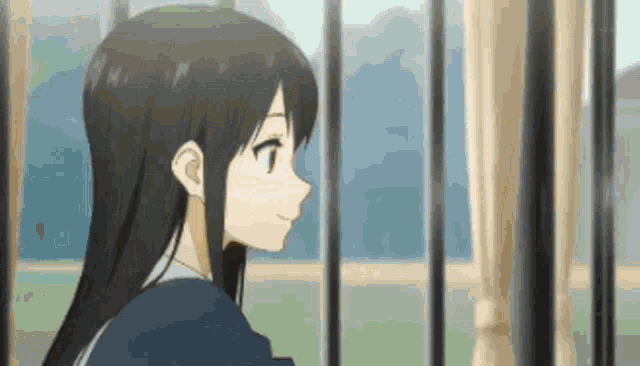 a girl with long black hair is looking out a window .