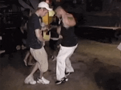 a group of men are dancing on a dance floor in a club .