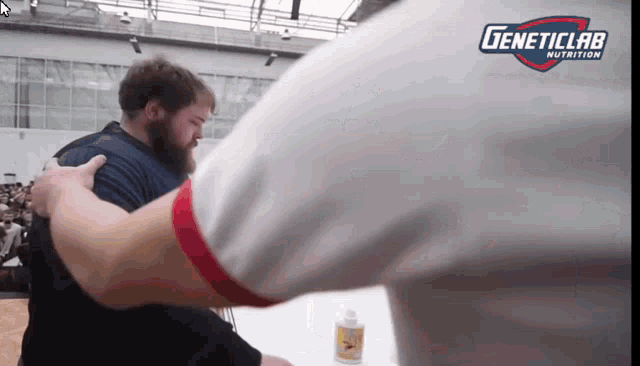 a geneticlab nutrition logo can be seen above a man 's arm