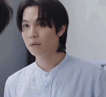 a man in a blue shirt looks at another man