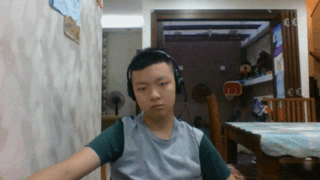 a boy wearing headphones looks at the camera in a room with a basketball hoop in the background