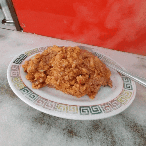 a plate of rice with a green and white border and a knife on it