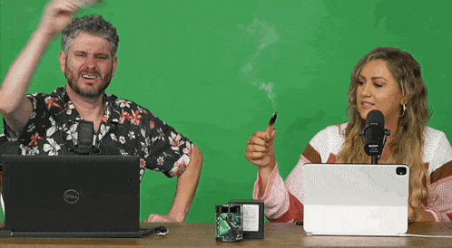 a man and a woman are sitting in front of a dell laptop .
