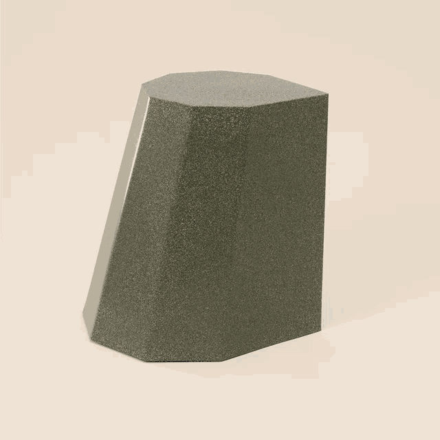 a gray block with a rounded corner is sitting on a beige surface