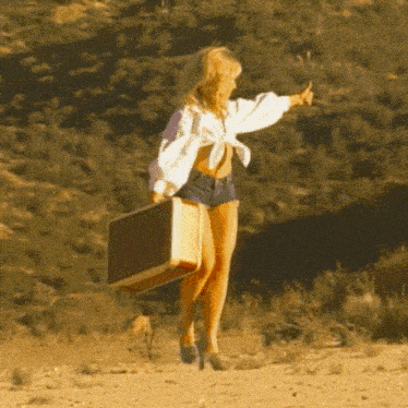 a woman with a suitcase is giving a thumbs up sign