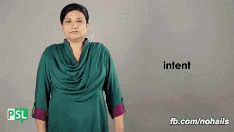 a woman in a green shirt is making a gesture that says intent