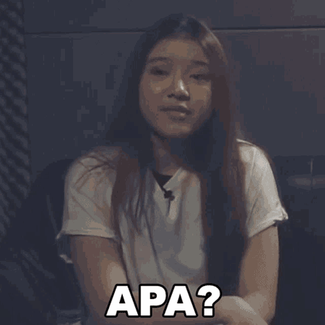a woman with long hair is wearing a white t-shirt and says apa