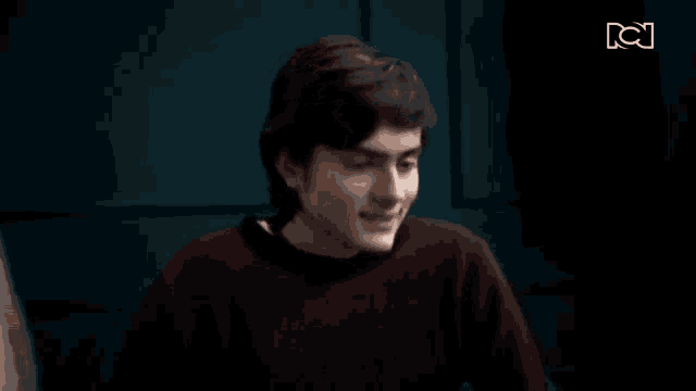 a blurry picture of a man in a red sweater in a dark room .