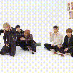 a group of young men are sitting on the floor and dancing .