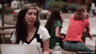 a woman is sitting at a table using a laptop computer .