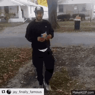 a man is walking down the street holding a bag of chips ..