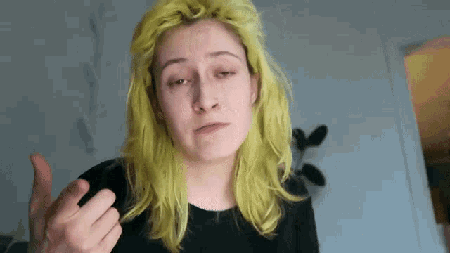 a woman with yellow hair is giving a middle finger
