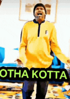 a man in a yellow sweatshirt is holding a sign that says otha kotta