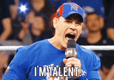 a man wearing a blue shirt that says i 'm talent screams into a microphone
