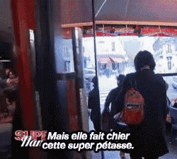 a woman with a red backpack is walking through a doorway with the words super mais elle fait chier mar cette super petasse