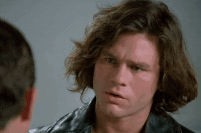 a man with long brown hair is wearing a leather jacket