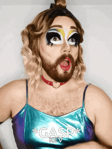 a drag queen with a beard is wearing a top that says gasp key