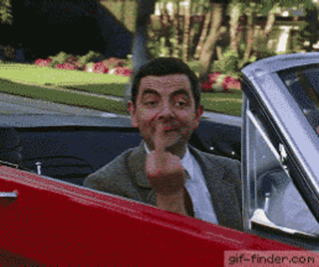 a man in a suit and tie giving the middle finger