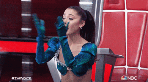 ariana grande is wearing a blue glove and covering her face