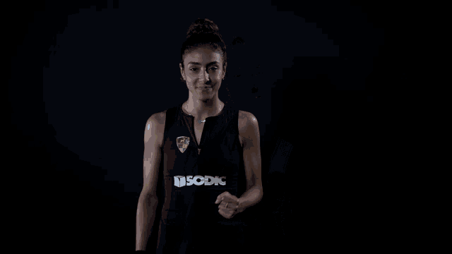 a woman wearing a black tank top that says usodic on it