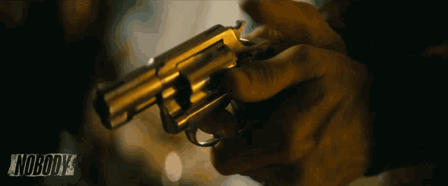 a close up of a person holding a gun with the word nobody on the bottom