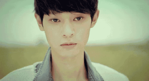 a close up of a young man 's face looking at the camera