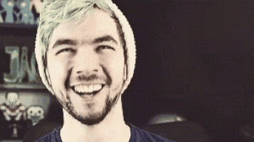 a man with green hair and a beard is smiling