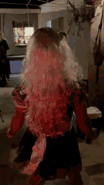 a little girl in a witch costume is dancing in a dark room .