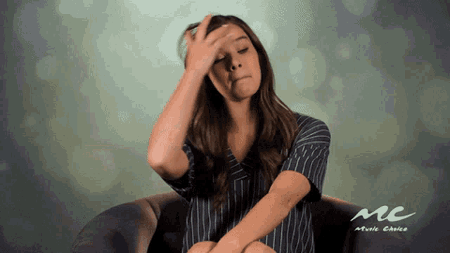 a woman sits in a chair with her hand on her head in front of a mc music choice logo