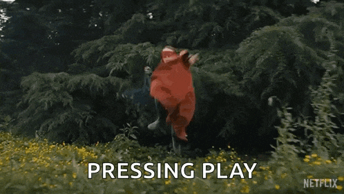 a person in a red costume is jumping in the air in a field .