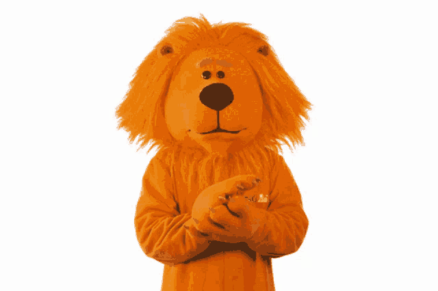 a lion mascot is wearing an orange sweater with the word abc on the sleeve
