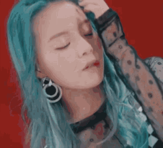 a close up of a woman 's face with blue hair .