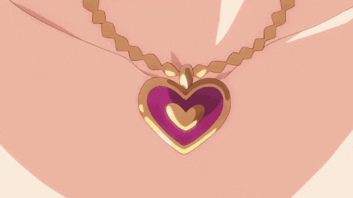 a close up of a woman 's chest with a heart necklace