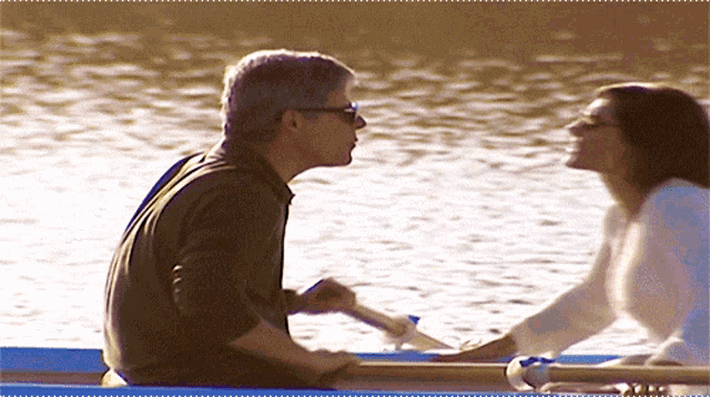 a man and woman are rowing a boat in the water