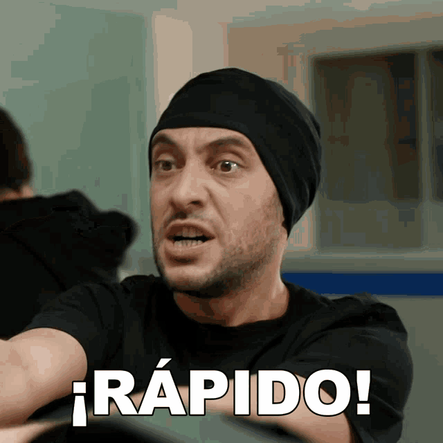 a man wearing a black beanie says rapido in spanish