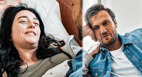 a man and a woman are laying in bed and the woman is smiling