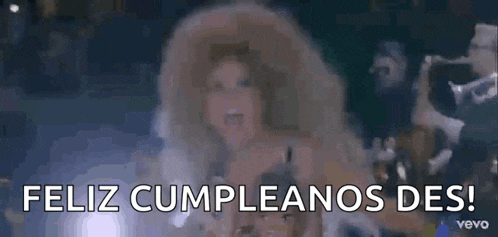 a woman with a big afro is saying feliz cumpleanos des in spanish .